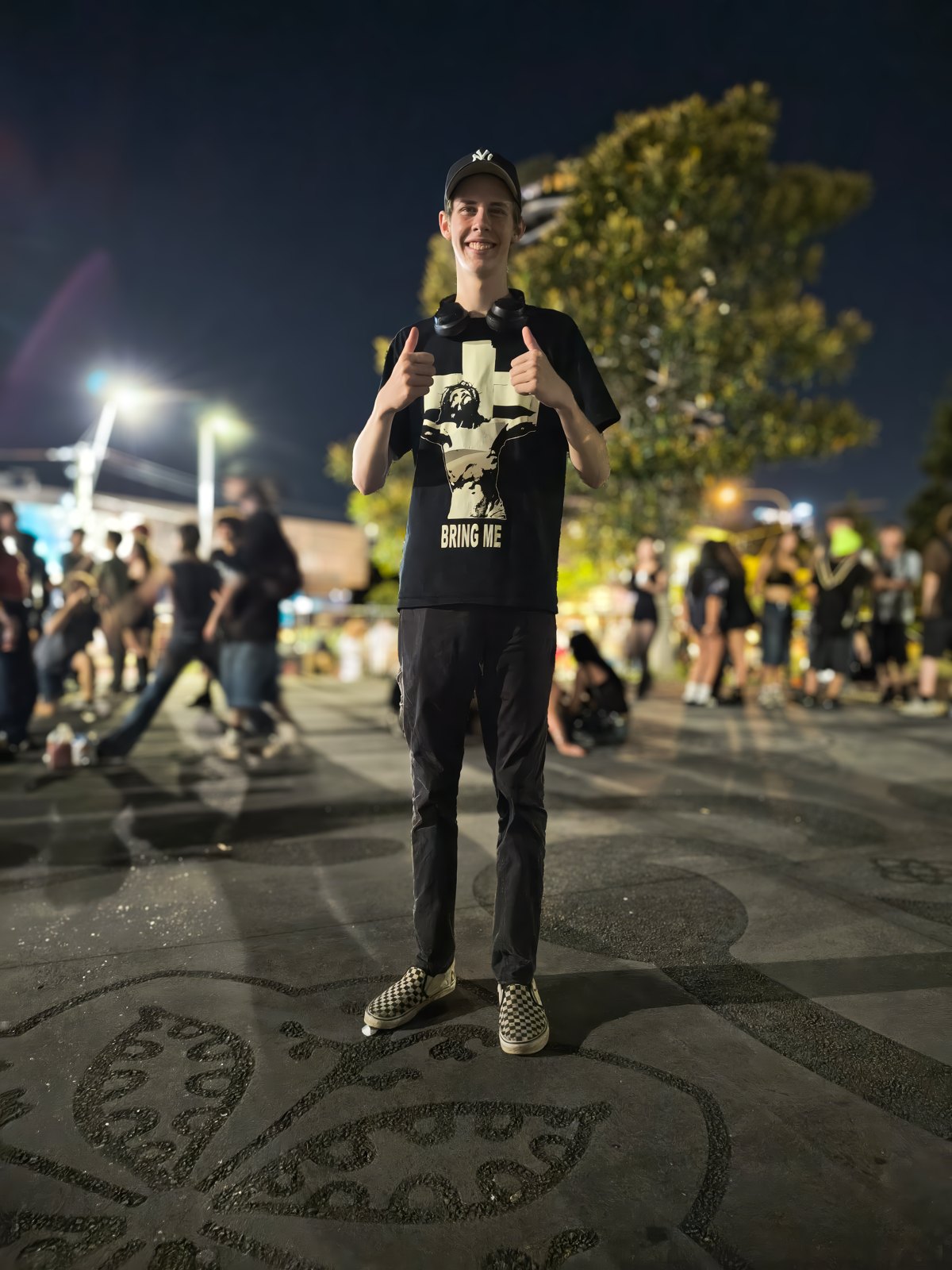 A lone figure facing a crowd under hard stage light